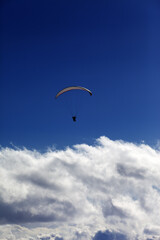 Silhouette of paraglider and blue sky with clouds