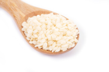 White sesame seeds organic in wooden spoon on white background. Health food concept.