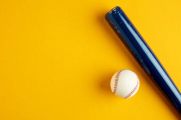 Blue wooden baseball bat and a baseball ball on yellow background.