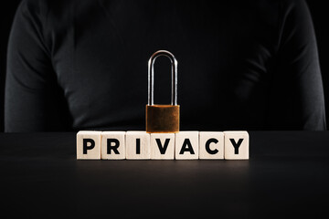 Padlock on wooden blocks with the word privacy. Privacy and security in business or technology