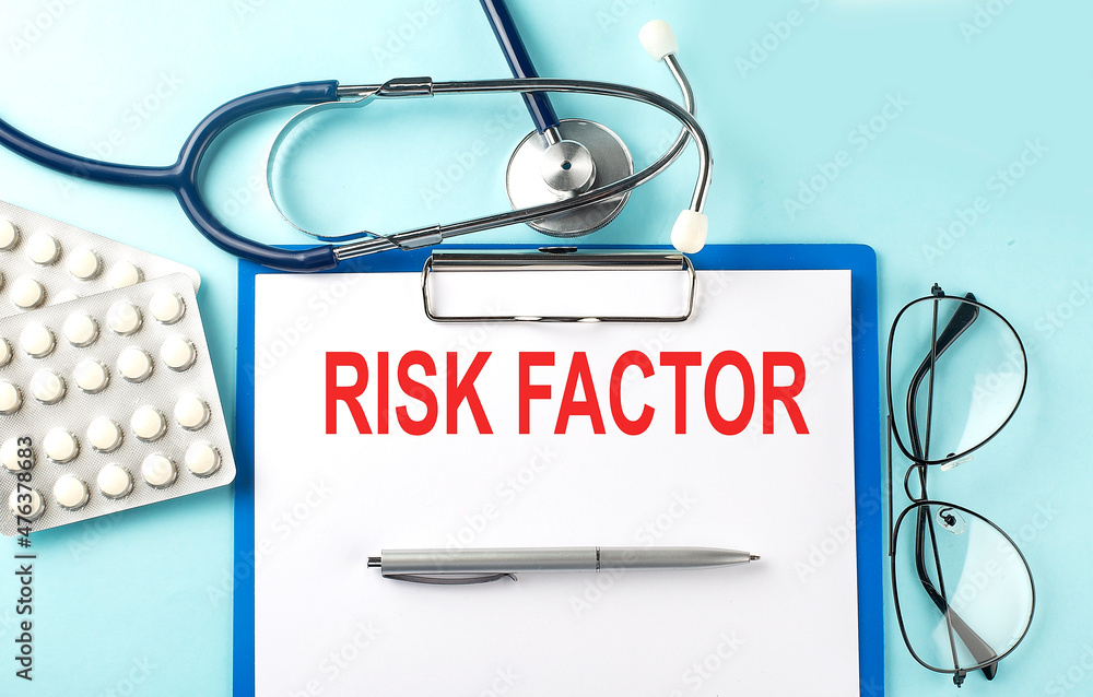 Poster paper with text risk factor on a blue background with stethoscope and pills