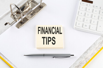 FINANCIAL TIPS - business concept, message on the sticker on folder background with calculator