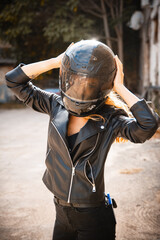 Portrait of a girl biker with a helmet on the street