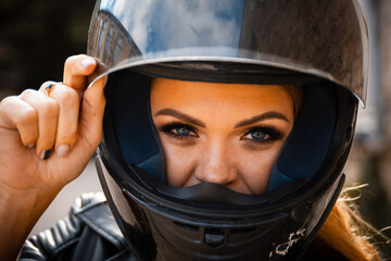 Portrait of a girl biker with a helmet on the street