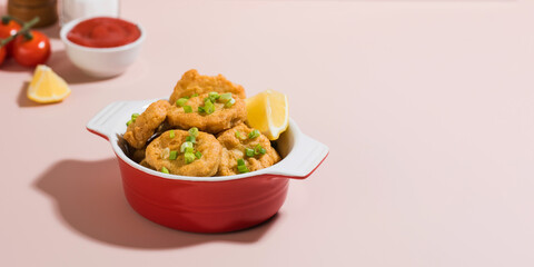 Banner crispy nuggets in a plate and ketchup on a pink background with hard shadows. Copy space.