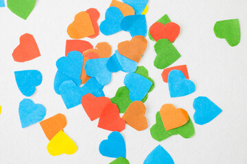 Love valentine's background with different color paper hearts. hearts cutted with scissors by kids. activities for kids. hamdame, craft. concept: love, valentines, banner, greeting
space for text.