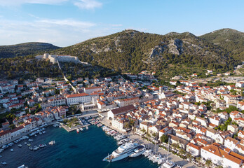 Naklejka na ściany i meble Streets of historic and tourist town of Hvar with fort, port and yacht marine, Croatian island otok in Mediterranean sea