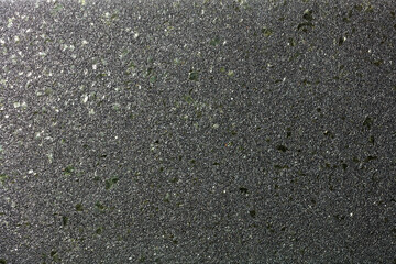 Black shiny background with fine grain texture and green malachite splashes for party decor.