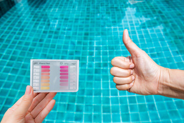 Best water quality concept, water tester and hand over clear blue swimming pool water, great...