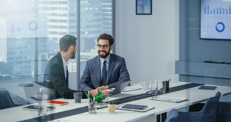 Businesspeople in Modern Office: Business Meeting of Two Businessmen Talking. CEO and Executive Strategy Brainstorming Ideas for Digital e-Commerce Software Investment. Handsome Happy Professionals