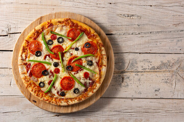 Traditional supreme pizza on rustic wooden table. Top view. Copy space