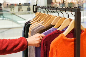 A man chooses clothes in a retail mall, close up.