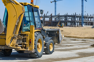 Yellow tractor with construction in the background.