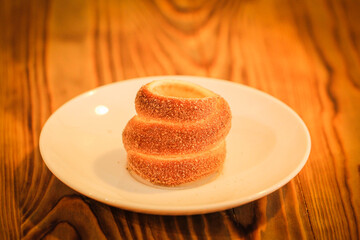 Photo of puff pastry rolls in sugar on plate. Traditional Transylvania Puff Bun. Close-up photo. Butter puff pattern. Bun with a hole inside. 