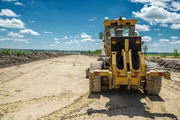 Yellow motor grader. Road construction.