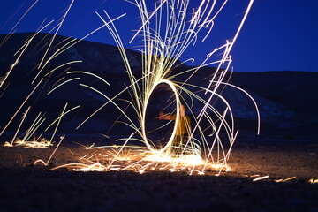 Iron wool circle drawing light fireworks. Burning Steel Wool spinning, Trajectories of burning sparks at night. Movement light effect, steel wool fire hoop. long exposure light painting, Pyrotechnic