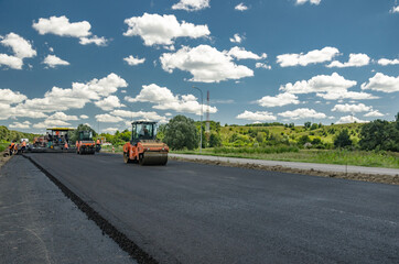 Fototapeta na wymiar Laying a new asphalt on the road. Construction of the road.