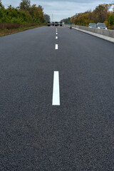 Road marking on the new asphalt on new road. Road construction.