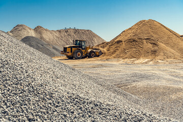 A large powerful loader overloads a sand in a concrete plant.