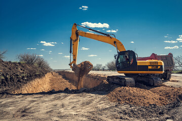 The excavator does earthwork. Digging a pit. - obrazy, fototapety, plakaty