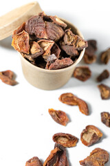 Dried apricots in a paper cup with a lid over white background. Top view.