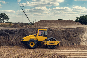 The vibratory roller compacts the soil in the excavation