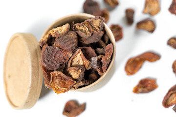 Dried apricots in a paper cup with a lid over white background. Top view.