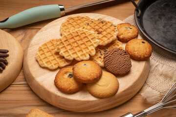 Homemade butter cookies and chocolate chip cookies and stick biscuits on wooden background ready to serve as snacks with tea and coffee on happy time.  