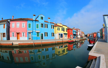 Fototapeta na wymiar colorful houses on the island of Burano near Venice in Northern Italy and the canal with the reflections