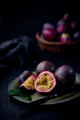 Obraz premium Fresh ripe passion fruits (maracuyas) on dark background with water drops