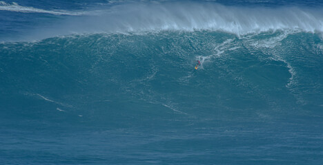 Fototapeta premium Sport photography. Jaws swell on International surfing event in Maui, Hawai 2021 December.