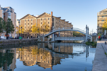 Obraz premium Paris, France - 10 24 2021: Reflections on the Ourcq canal of the lift bridge at sunrise