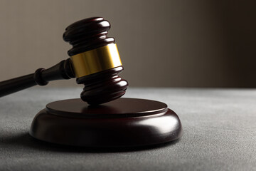 Law theme, mallet of the judge on wooden desk with Lady Justice Statue. Law gavel on dark foggy...