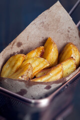 sliced and fried potatoes in paper packaging in a cafe