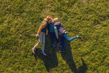 family top view. lying on the grass. sunny day. in green nature together. Aerial view Drone photography