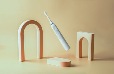 Ultrasonic toothbrush in levitation on beige background with podiums.Modern dental care still life concept