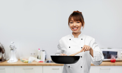 food cooking, culinary and people concept - happy smiling female chef with frying pan over kitchen...