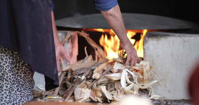 Female making bread In the oriental courtyard. Lit the firewood to bake bread