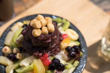 Bean bingsu, a Korean dessert eaten in summer topped with milk, various fruits, rice cakes, and red...