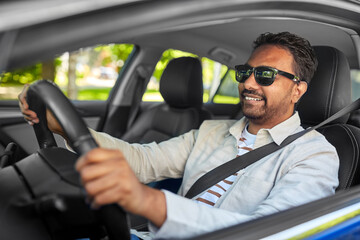 transport, vehicle and people concept - happy smiling indian man or driver in sunglasses driving car