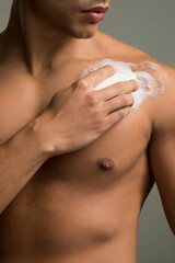 Fototapeta premium Close-up of man applying soap on chest