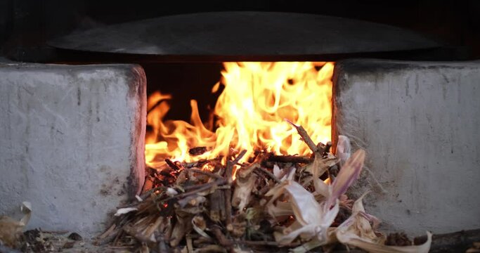 In the oriental courtyard, a fire burns in a medieval stove. lit the firewood to bake bread