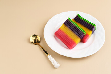 Kue Lapis or Kue Pepe or Rainbow sticky layer cake, Indonesian traditional dessert made from rice flour and coconut milk, steamed layer by layer. Served in white plate, copy space. Selective focus.
