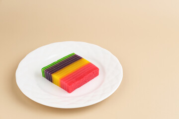 Kue Lapis or Kue Pepe or Rainbow sticky layer cake, Indonesian traditional dessert made from rice flour and coconut milk, steamed layer by layer. Served in white plate, copy space. Selective focus.
