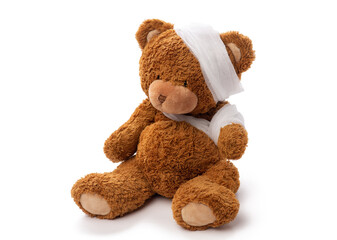 medicine, healthcare and childhood concept - teddy bear toy with bandaged head and paw on white background