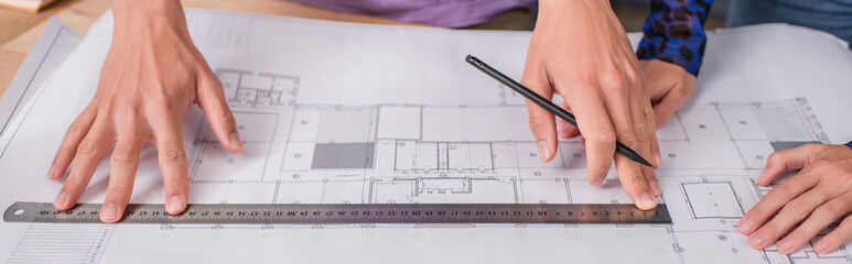 cropped view of interior designers working with blueprint, banner.