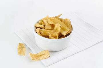 Heap of dried banana chips snack on white background. Selective focus image, blurred background.

