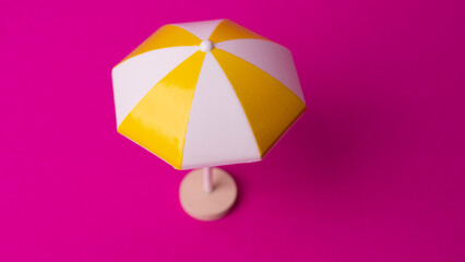 multicolored beach umbrella on pink background