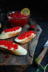 Red caviar on a dark background. Sandwiches with caviar