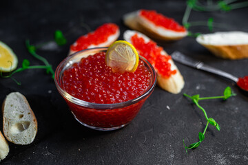 Red caviar on a dark background. Sandwiches with caviar